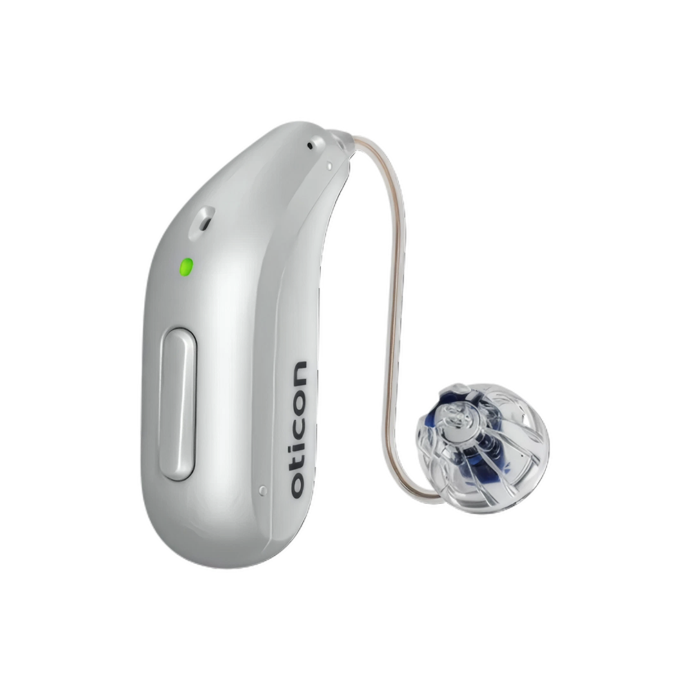 En un fondo blanco liso se muestra un audífono Oticon Reveal™ 2 de color plateado con tecnología 4D Sensor, un indicador LED verde, un cable curvo y un receptor transparente, que ofrece una claridad de voz avanzada.