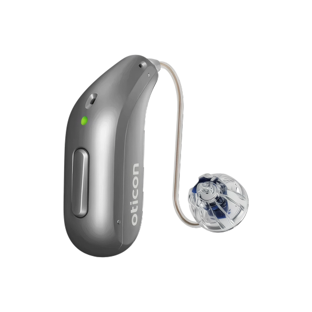 Un audífono Oticon Reveal™ 2 de color plateado, equipado con tecnología 4D Sensor, tubo auricular curvado y auricular transparente tipo cúpula, se presenta sobre un fondo blanco. El dispositivo ofrece una claridad del habla avanzada para una experiencia auditiva superior.