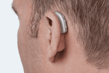 Audífono Oticon More, modelo miniRITE R, color Gris claro, foto tomada desde atrás en un ángulo de 45°, primer plano de la oreja, Audífonos masculinos con servicio ilimitado Auzen